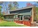 Green home exterior offers a deck, a screened-in porch, and access to a well-manicured lawn at 2411 Mitchell Ne Rd, Marietta, GA 30062