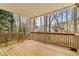 Spacious covered back deck features wooden railing and wooded views at 2611 Winterthur Main Nw, Kennesaw, GA 30144