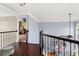 Hallway with hardwood floors, iron railings, and views into other rooms at 2611 Winterthur Main Nw, Kennesaw, GA 30144