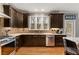 Well-appointed kitchen features dark wood cabinets, granite countertops, stainless steel appliances, and hardwood floors at 2611 Winterthur Main Nw, Kennesaw, GA 30144
