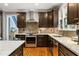 Modern kitchen features dark wood cabinetry, stainless steel appliances, a stylish hood, and granite countertops at 2611 Winterthur Main Nw, Kennesaw, GA 30144