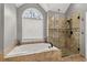 Main bathroom features a soaking tub, glass shower, and natural light from a window at 2611 Winterthur Main Nw, Kennesaw, GA 30144
