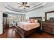 Spacious main bedroom with tray ceiling, fan, hardwood floors, and a seating area at 2611 Winterthur Main Nw, Kennesaw, GA 30144