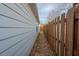 A narrow side yard with a wooden fence and a view of the light-green siding of the home at 4531 Flowering Br, Powder Springs, GA 30127
