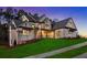 Beautifully lit home at dusk featuring a sprawling lawn and manicured landscaping, perfect for evening gatherings and curb appeal at 4921 Slaton Dr, Acworth, GA 30101