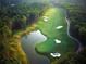 Aerial view of a lush golf course featuring a pond, sand traps, and manicured green fairways at 4921 Slaton Dr, Acworth, GA 30101