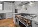 Gourmet kitchen featuring a stainless steel range with pot filler, custom cabinets, and hardwood floors at 4921 Slaton Dr, Acworth, GA 30101