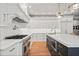Bright kitchen with stainless steel appliances, oversized island, and custom white cabinets with gold hardware at 4921 Slaton Dr, Acworth, GA 30101
