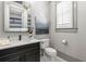 Chic powder room with a marble countertop, decorative mirror, modern fixtures, and natural light from the window at 4921 Slaton Dr, Acworth, GA 30101