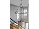 Modern chandelier hangs from high ceilings with a view of the barn doors and staircase at 4921 Slaton Dr, Acworth, GA 30101
