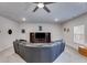 Finished basement featuring a large seating area, neutral carpet, a ceiling fan, and a television at 197 Saddleridge Dr, Bremen, GA 30110