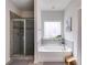 Bathroom with shower, tub, large window, and neutral tile at 197 Saddleridge Dr, Bremen, GA 30110