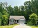 Charming brick home features a two-car garage and landscaped front yard, nestled among mature trees at 197 Saddleridge Dr, Bremen, GA 30110