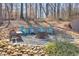 Charming fire pit area with chairs set amongst the trees on a stone base at 197 Saddleridge Dr, Bremen, GA 30110