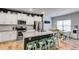 Open kitchen with granite island, white cabinets, stainless appliances, and eat-in dining area at 197 Saddleridge Dr, Bremen, GA 30110