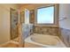 Bathroom with a soaking tub, separate glass shower, and a tiled wall at 60 Streamside Dr, Covington, GA 30016