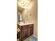This powder room includes a pedestal sink with marble countertop, decorative lighting, and wood stained cabinets at 60 Streamside Dr, Covington, GA 30016