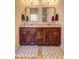 Bathroom featuring double sinks with dark wood cabinets and matching rugs at 60 Streamside Dr, Covington, GA 30016