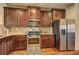 Well-equipped kitchen featuring stainless appliances, wood cabinets and granite countertops at 60 Streamside Dr, Covington, GA 30016