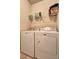 Functional laundry area with Maytag washer and dryer and upper shelving providing ample storage at 60 Streamside Dr, Covington, GA 30016