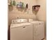 Bright laundry room with modern Maytag washer and dryer, and wire rack for storage of laundry supplies at 60 Streamside Dr, Covington, GA 30016