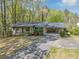 Front exterior view of the home featuring a long driveway, attached carport, and landscaped yard at 9258 Westview Sw Dr, Covington, GA 30014