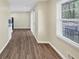 Hallway with wood-look flooring leading to kitchen, featuring a window and neutral wall color at 9258 Westview Sw Dr, Covington, GA 30014