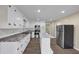 Well-lit kitchen featuring stainless steel appliances, white cabinets, a marbled countertop, and wood-style floors at 9258 Westview Sw Dr, Covington, GA 30014