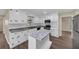 Bright kitchen featuring white cabinets, stainless steel appliances, gray countertops, and a central island at 9258 Westview Sw Dr, Covington, GA 30014