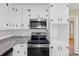 Close-up of kitchen appliances and white cabinets with black hardware, complemented by light countertops at 9258 Westview Sw Dr, Covington, GA 30014