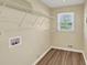 Bright laundry area features wood-look flooring, white wire shelving, and a window that offers natural light at 9258 Westview Sw Dr, Covington, GA 30014
