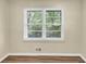Well-lit room featuring wood-look floors, a large window with blinds, and a neutral color palette at 9258 Westview Sw Dr, Covington, GA 30014