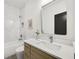 Well-lit bathroom featuring marble tiled shower/bathtub combination, floating vanity, and sleek modern mirror at 1171 State St # B, Atlanta, GA 30318