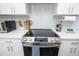 Close up of range in kitchen with stainless steel appliances, microwave and paper towels on white counters at 224 Ormond Sw St # A, Atlanta, GA 30315