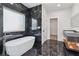 Modern bathroom with freestanding tub, sleek fixtures, and elegant dark marble tile surround at 2312 Herring Sw Rd, Atlanta, GA 30311