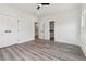 Bright bedroom features gray flooring, ceiling fan, and doors to the closet and bathroom at 2312 Herring Sw Rd, Atlanta, GA 30311