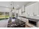 Modern kitchen features white cabinets, a black countertop island, and stainless steel appliances at 2312 Herring Sw Rd, Atlanta, GA 30311