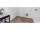 Bright laundry room with modern black utility sink and wood-look floors at 2312 Herring Sw Rd, Atlanta, GA 30311