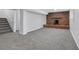 Spacious basement with gray carpet, brick fireplace, and stairs leading to upper level at 4564 Cypress Ridge Ct, Stone Mountain, GA 30083