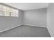 Bedroom showcasing gray walls and carpet, complemented by natural light from the window at 4564 Cypress Ridge Ct, Stone Mountain, GA 30083
