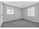 Bright bedroom with neutral walls, gray carpet, and two windows at 4564 Cypress Ridge Ct, Stone Mountain, GA 30083