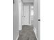 Hallway with neutral walls, gray carpet, and white doors at 4564 Cypress Ridge Ct, Stone Mountain, GA 30083