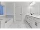 Bright bathroom with a modern vanity, a soaking tub with marble accents, and stylish fixtures at 656 Avondale Park Cir, Decatur, GA 30032