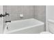 Bathroom with tiled shower and tub featuring modern hardware and fixtures at 656 Avondale Park Cir, Decatur, GA 30032