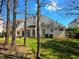 Large backyard with a well-maintained lawn, mature trees, and patio area at 275 Rose Ivy Ct, Lawrenceville, GA 30043