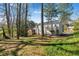 House backyard surrounded by tall trees with a deck on the side at 3274 Adelade Ct, Lithonia, GA 30038