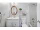 Cozy, white bathroom with a decorative mirror and plant on shelving above the toilet at 3274 Adelade Ct, Lithonia, GA 30038