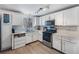 Modern kitchen with stainless appliances, white cabinetry, and a window overlooking the backyard at 3274 Adelade Ct, Lithonia, GA 30038