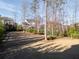 Wide view of the large backyard, bordered by mature trees and neighboring homes at 12640 Hearthstone Way, Alpharetta, GA 30009