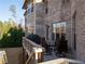 A view of the backyard, brick exterior and a deck with outdoor seating and a grill at 12640 Hearthstone Way, Alpharetta, GA 30009